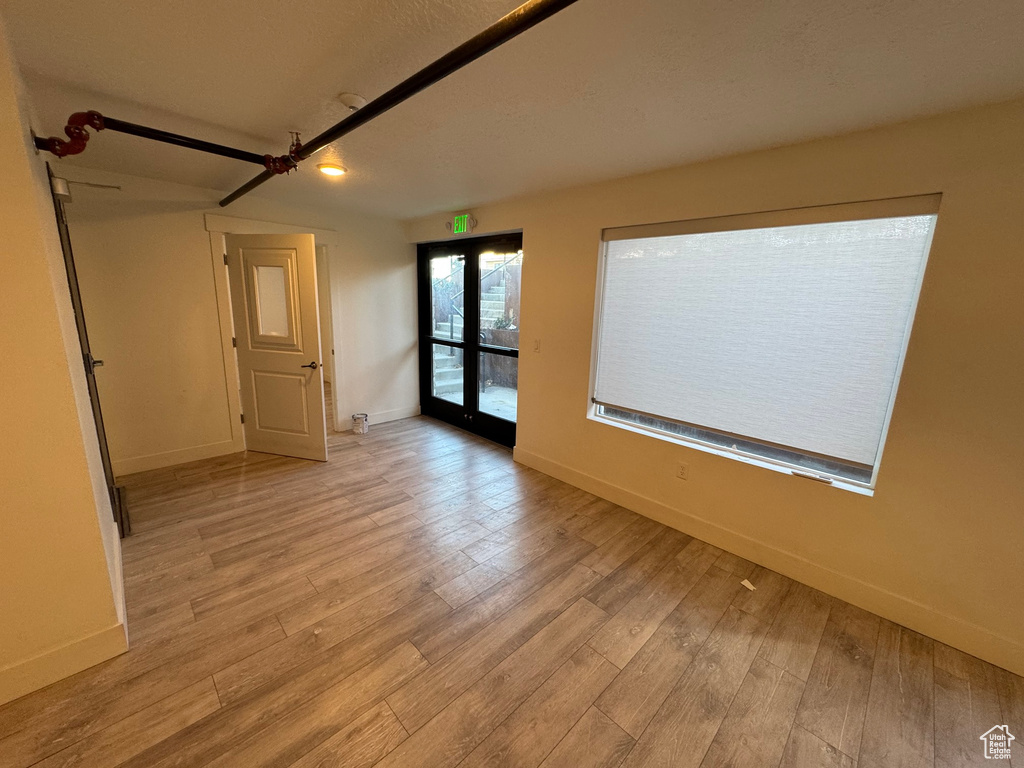 Empty room featuring baseboards and light wood-style flooring