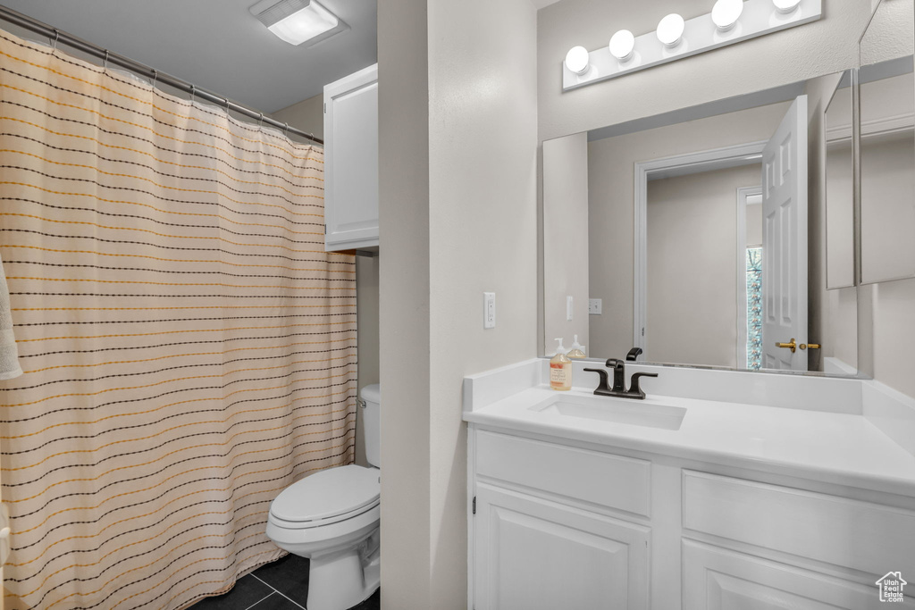 Full bathroom featuring vanity, tile patterned flooring, toilet, and curtained shower