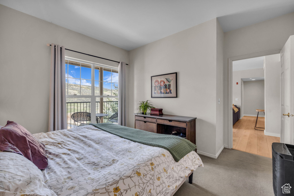 Bedroom with baseboards, carpet flooring, and access to exterior