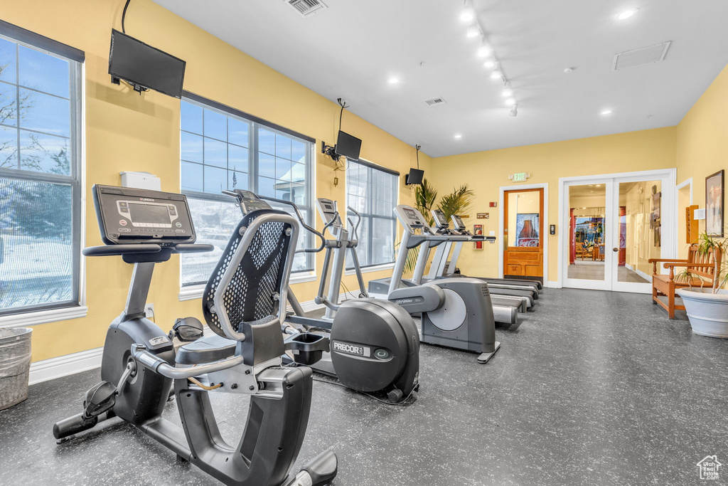 Workout area with french doors, rail lighting, visible vents, and baseboards