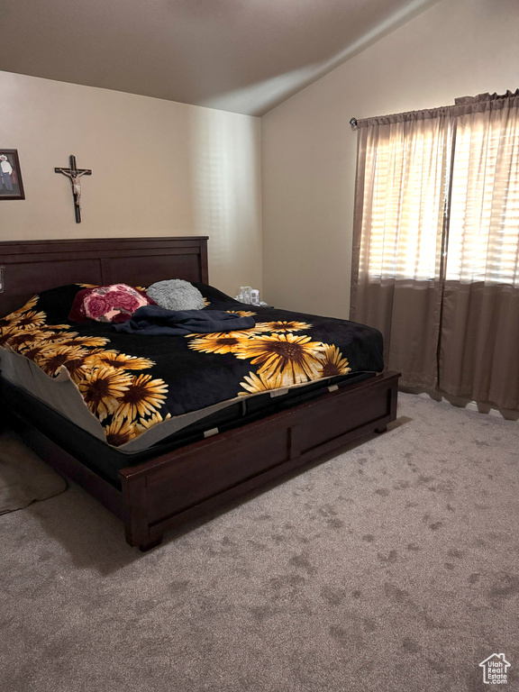 Carpeted bedroom featuring vaulted ceiling