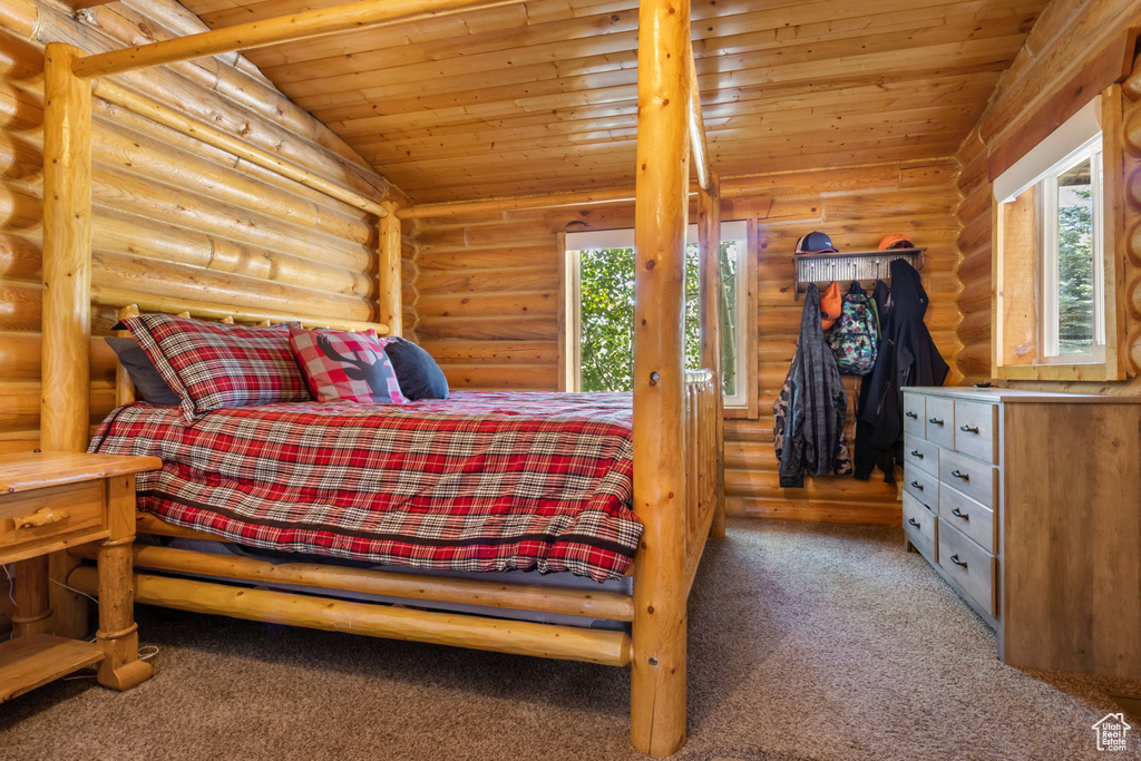 Bedroom with log walls, carpet, and wood ceiling