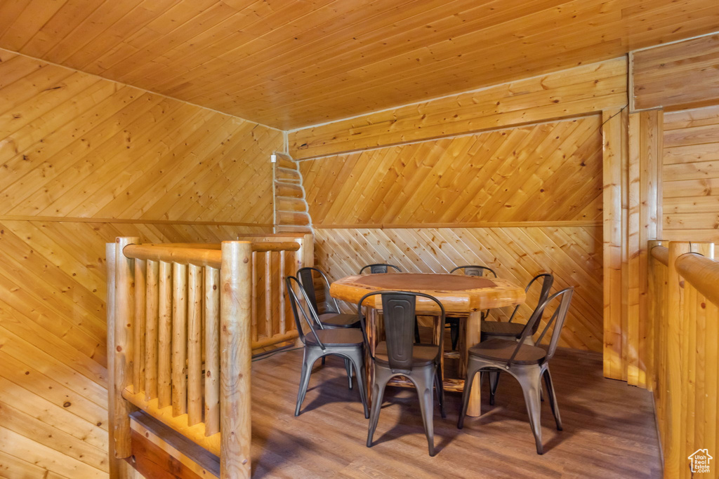 Dining room with wood walls, wood ceiling, and wood finished floors
