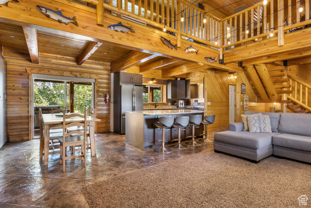 Kitchen featuring log walls, wood ceiling, a wealth of natural light, and beamed ceiling