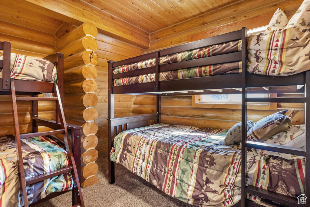 Bedroom featuring carpet flooring, rustic walls, and wooden ceiling