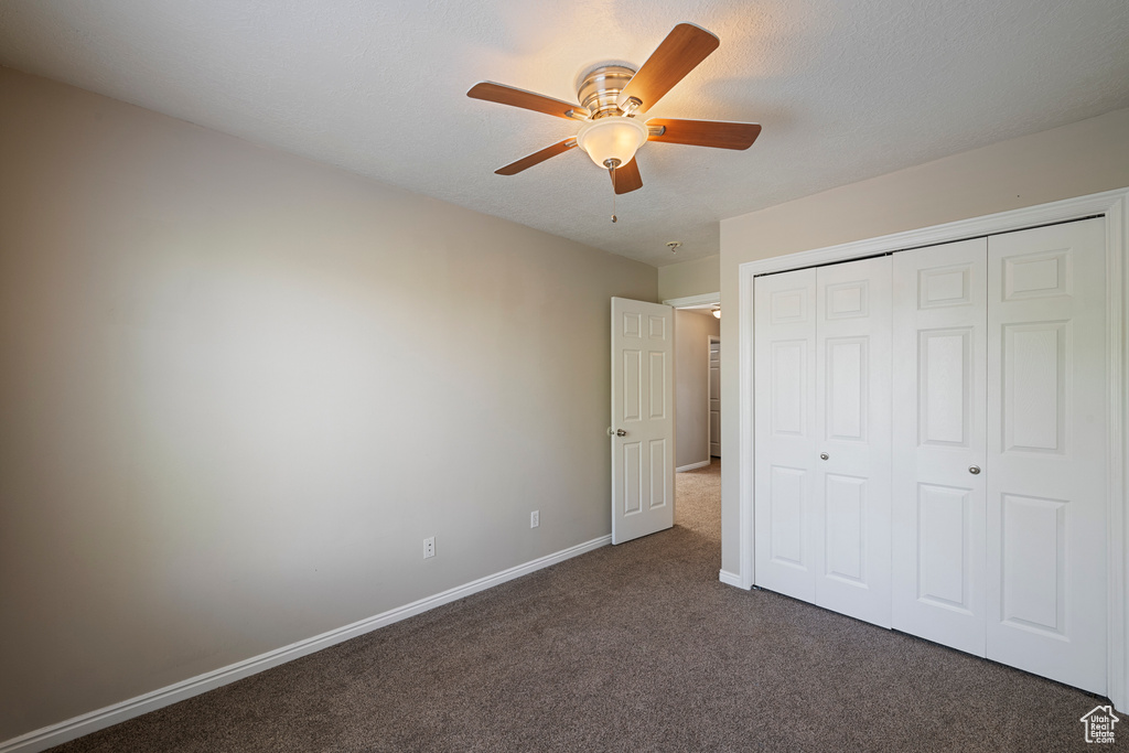 Unfurnished bedroom with carpet floors, baseboards, ceiling fan, and a closet