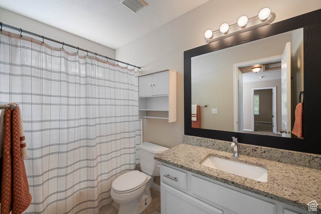 Full bath with visible vents, toilet, and vanity