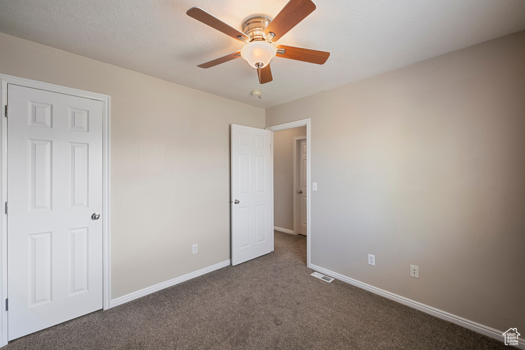 Unfurnished bedroom featuring baseboards, carpet flooring, ceiling fan, and visible vents
