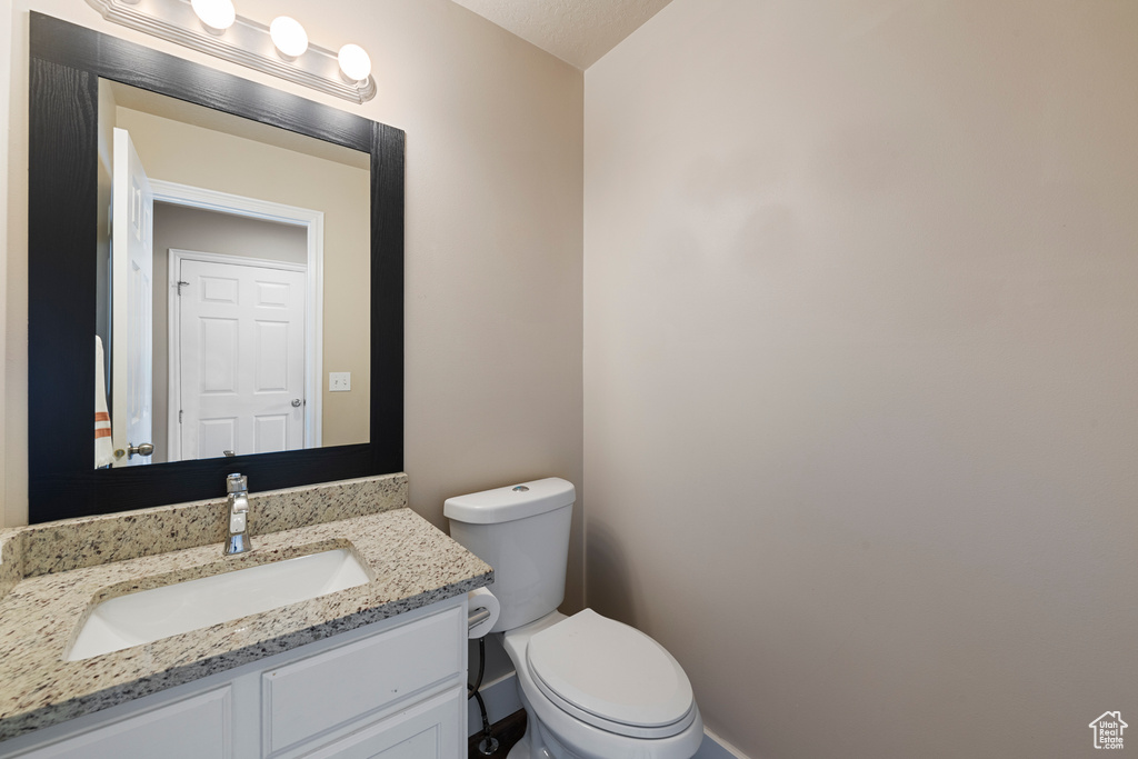 Bathroom with vanity, baseboards, and toilet