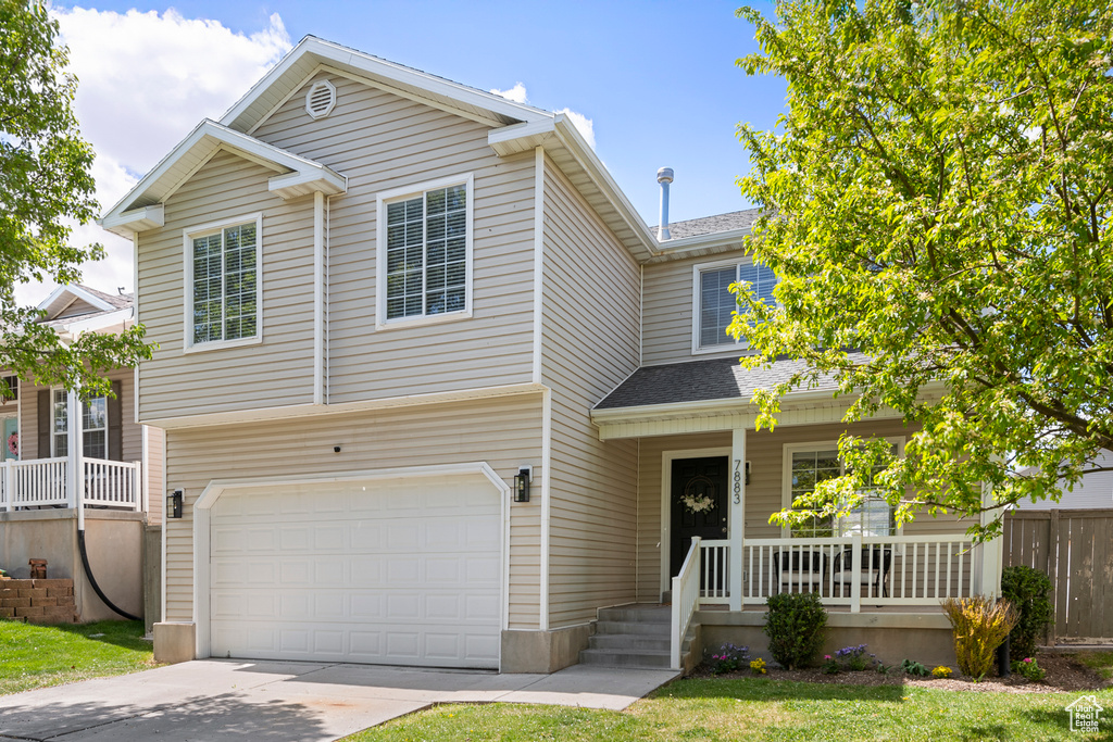 View of front of property with a garage, a shingled roof, concrete driveway, and a porch