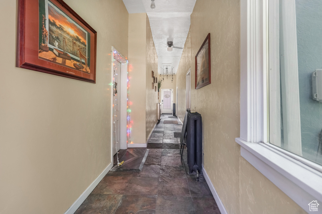 Corridor with baseboards and stone finish floor