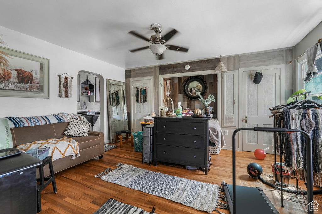 Living area featuring a ceiling fan, arched walkways, and wood finished floors