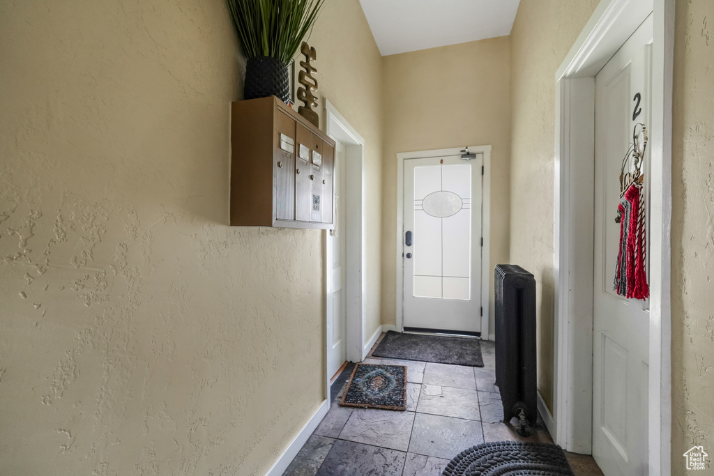Doorway to outside with baseboards and a textured wall