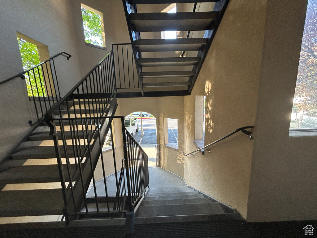 Staircase with plenty of natural light and a towering ceiling