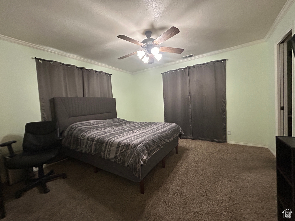 Carpeted bedroom with crown molding, ceiling fan, and visible vents