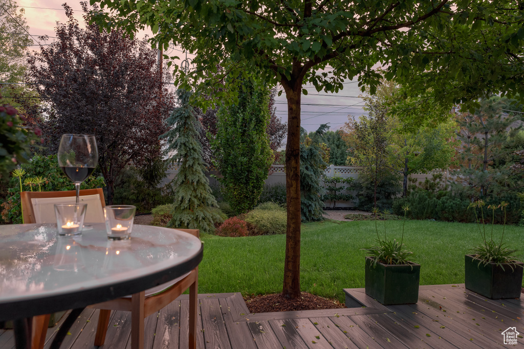 Wooden deck featuring a lawn and fence
