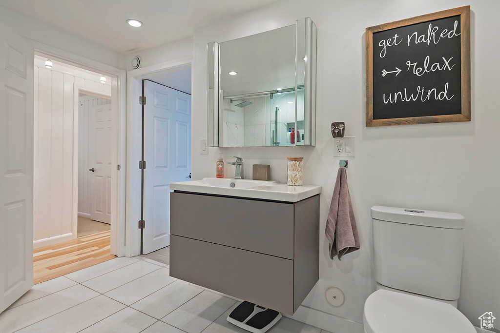 Bathroom with tile patterned flooring, vanity, toilet, a shower with door, and recessed lighting