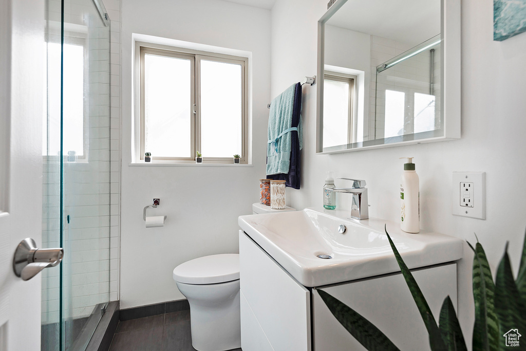 Bathroom featuring vanity, baseboards, toilet, and a shower stall