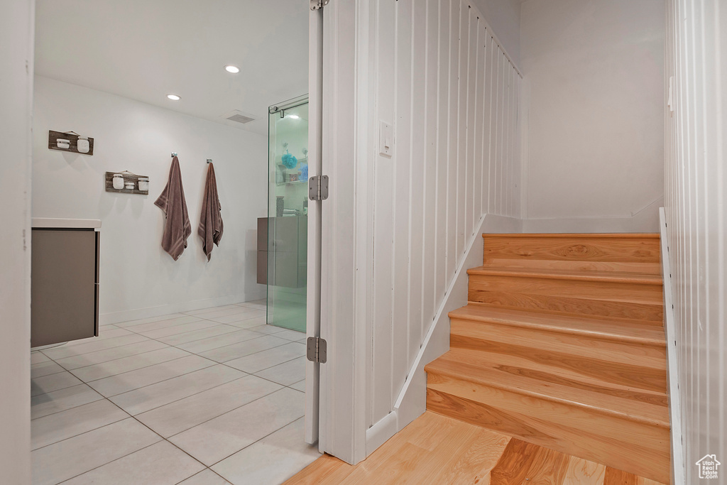 Stairway with recessed lighting, tile patterned floors, visible vents, and baseboards