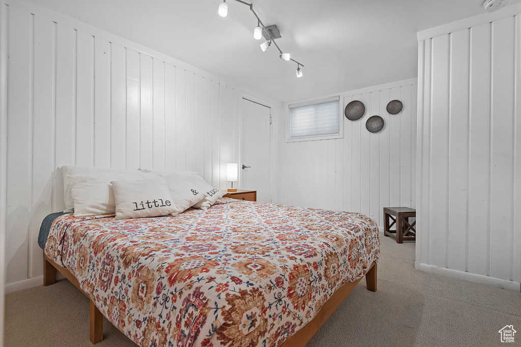 Bedroom with carpet floors and wooden walls