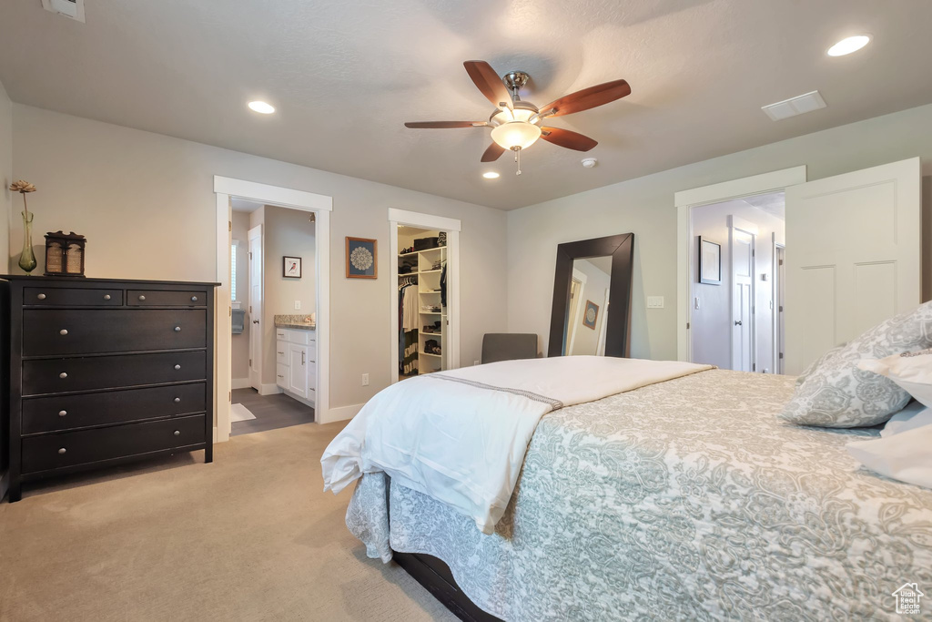 Bedroom with a closet, light colored carpet, recessed lighting, and a spacious closet