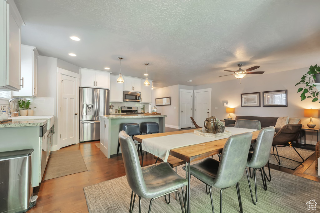 Dining area with ceiling fan, light wood-type flooring, recessed lighting, and a textured ceiling
