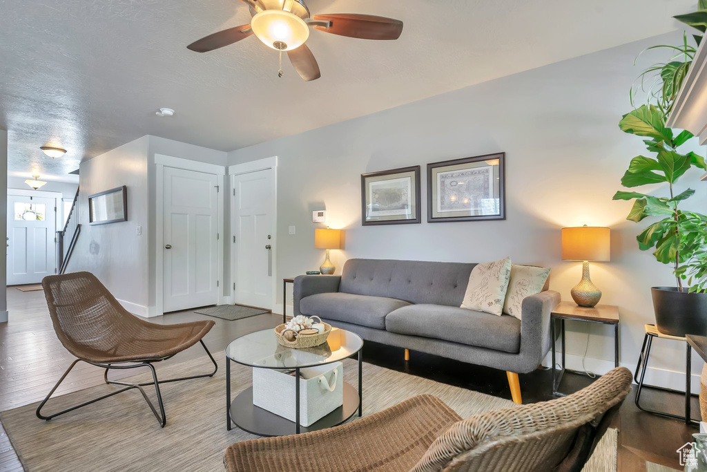 Living area featuring baseboards, ceiling fan, and wood finished floors