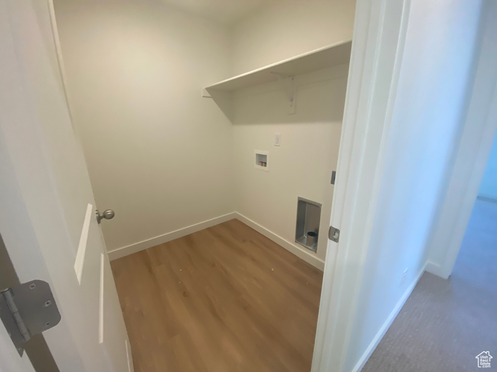 Washroom featuring baseboards, laundry area, hookup for a washing machine, and wood finished floors