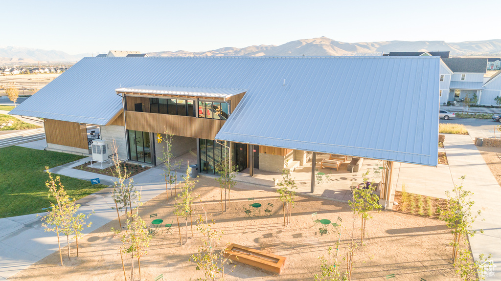 Rear view of house with central AC, metal roof, a mountain view, and a patio area