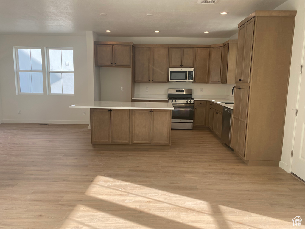 Kitchen featuring recessed lighting, baseboards, appliances with stainless steel finishes, and light wood-style floors