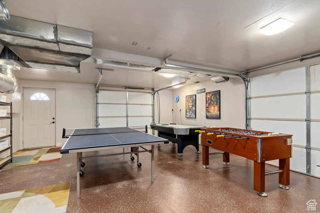 Recreation room featuring a garage and speckled floor