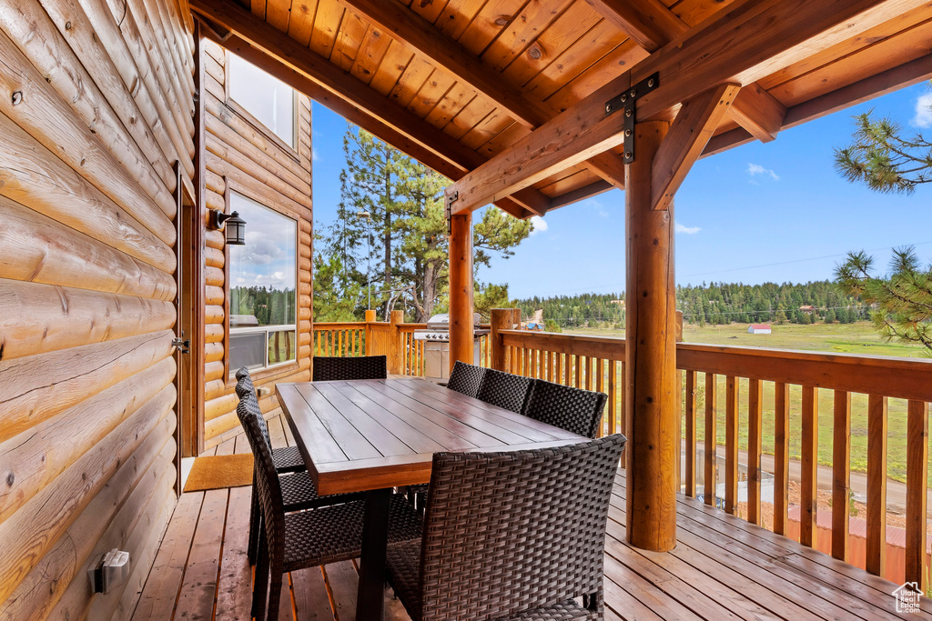 Wooden terrace with outdoor dining area and a grill