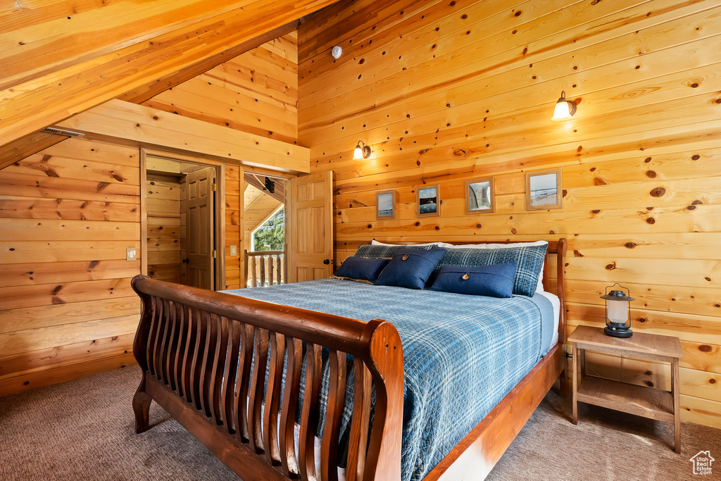 Bedroom featuring wooden walls, carpet, and access to exterior