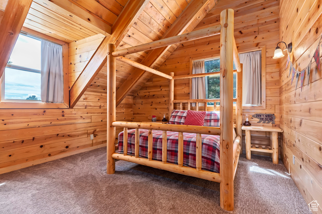 Carpeted bedroom featuring wood ceiling, wood walls, and vaulted ceiling with beams