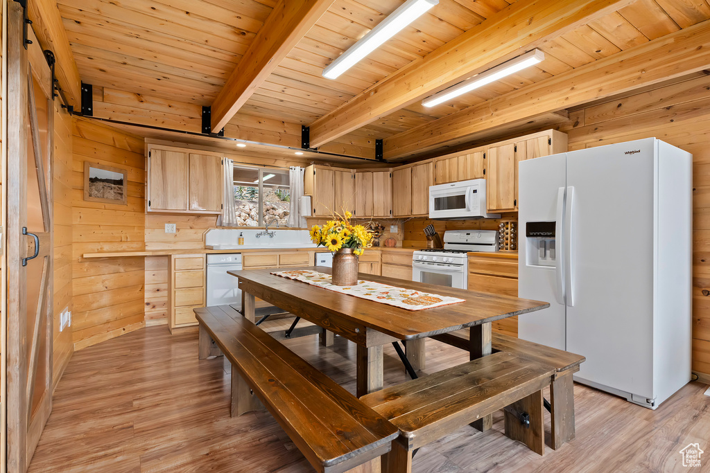 Kitchen featuring beam ceiling, light brown cabinets, white appliances, light countertops, and wooden ceiling