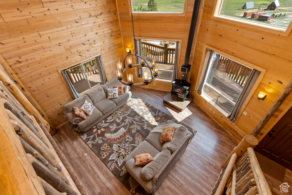 Living room with a wood stove, wood finished floors, and wooden walls