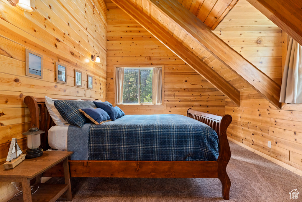 Bedroom with carpet floors, wood walls, lofted ceiling with beams, and wood ceiling