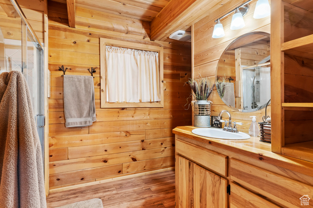 Bathroom featuring vanity, wood finished floors, wooden walls, wooden ceiling, and a shower stall