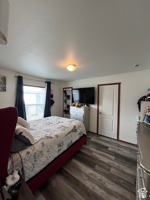 Bedroom featuring dark wood-type flooring and a textured ceiling