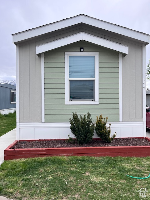 View of side of home featuring a yard