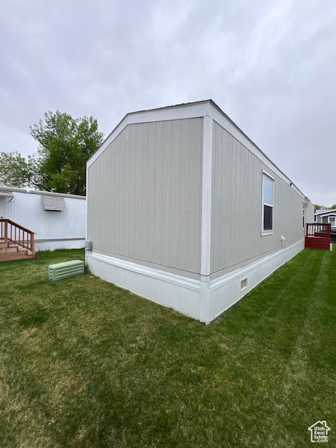 View of side of home featuring a lawn