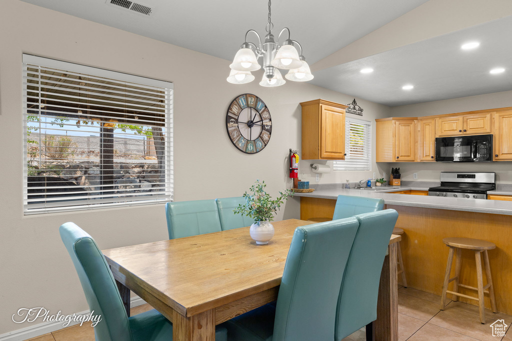 Dining area featuring a notable chandelier, recessed lighting, light tile patterned floors, lofted ceiling, and visible vents