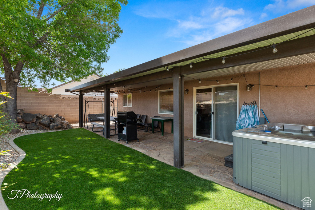 Exterior space with a hot tub, fence, and a patio area