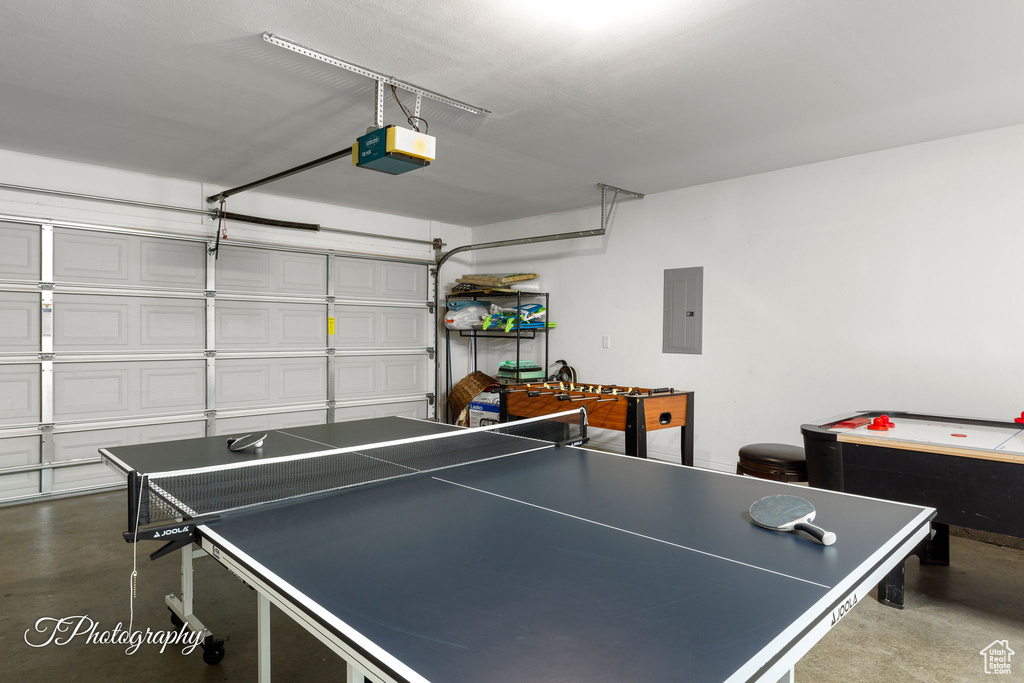 Game room featuring a garage, concrete flooring, and electric panel