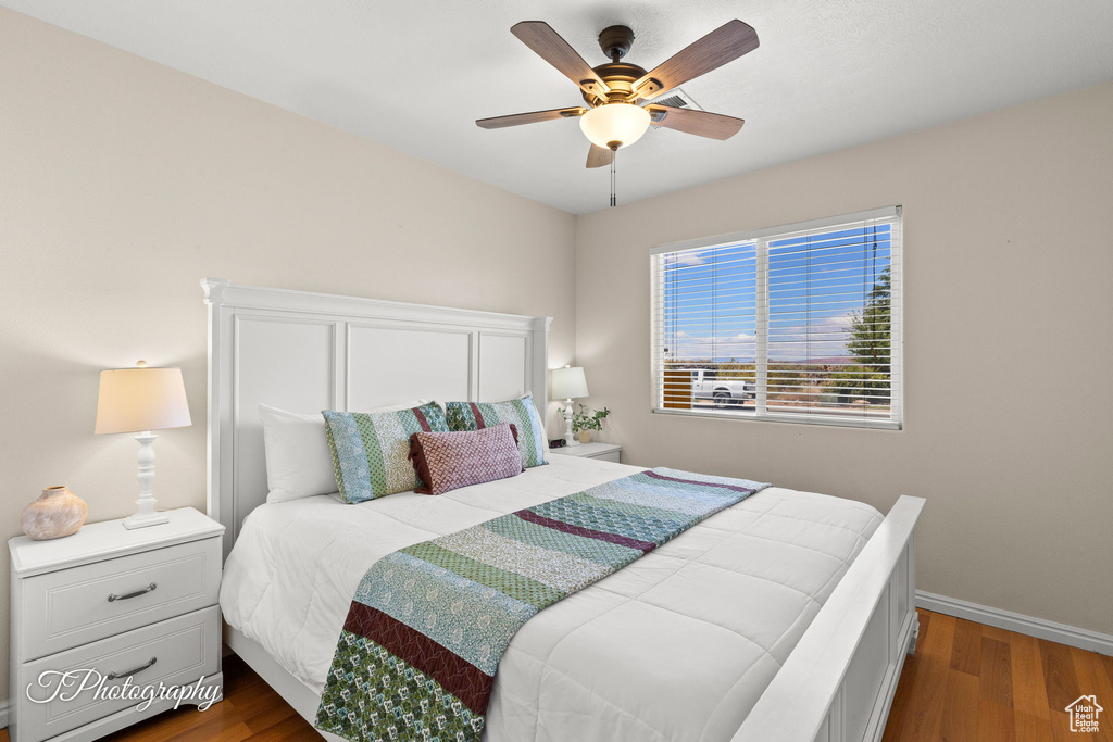 Bedroom with dark wood-style flooring, baseboards, and ceiling fan