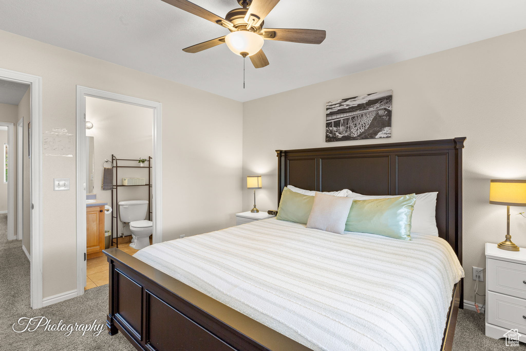 Bedroom featuring connected bathroom, a ceiling fan, baseboards, and light colored carpet