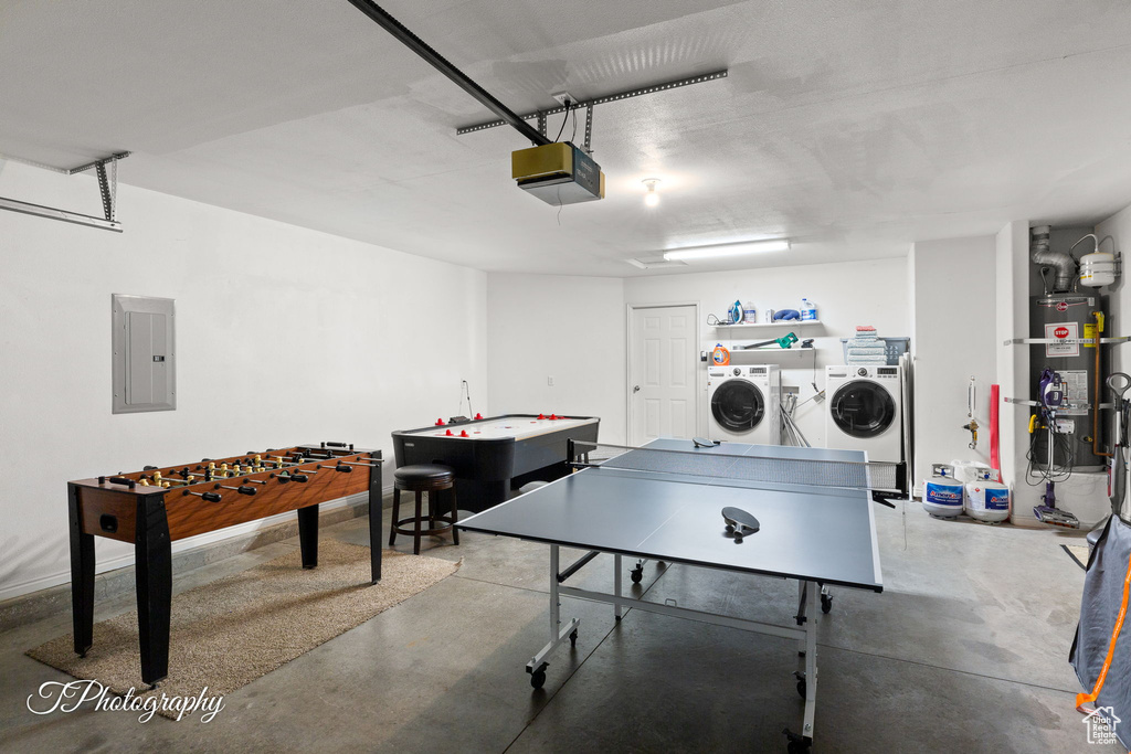 Rec room featuring secured water heater, separate washer and dryer, concrete floors, and electric panel