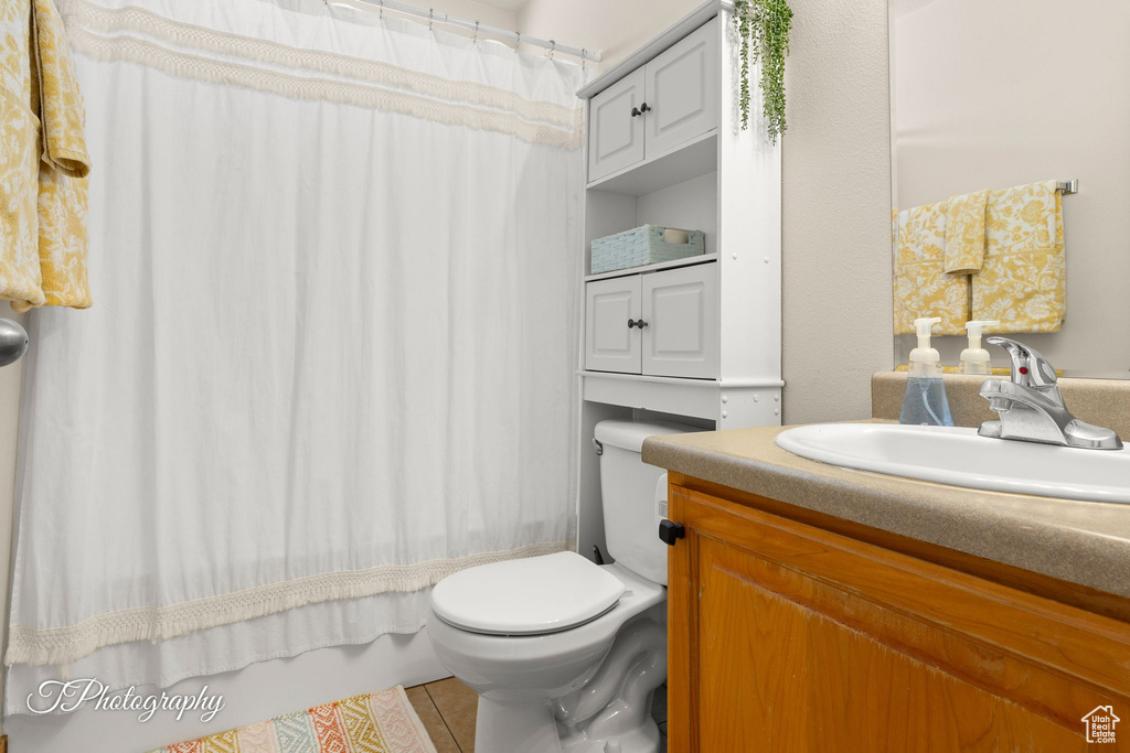 Bathroom featuring toilet, tile patterned flooring, and vanity