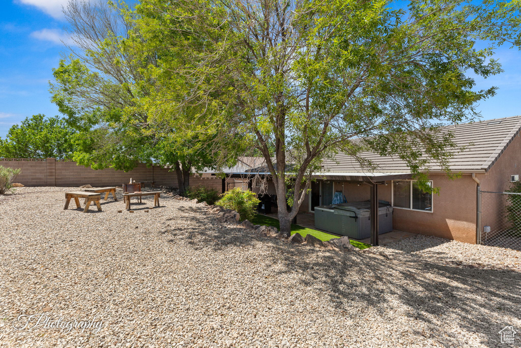 View of yard with a fenced backyard and a hot tub