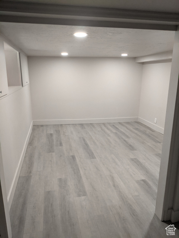 Finished below grade area featuring recessed lighting, baseboards, and wood finished floors
